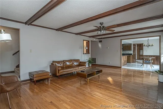 a living room with furniture a ceiling fan and a rug