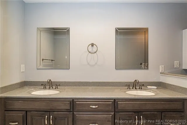 a bathroom with a sink vanity granite toilet and a mirror