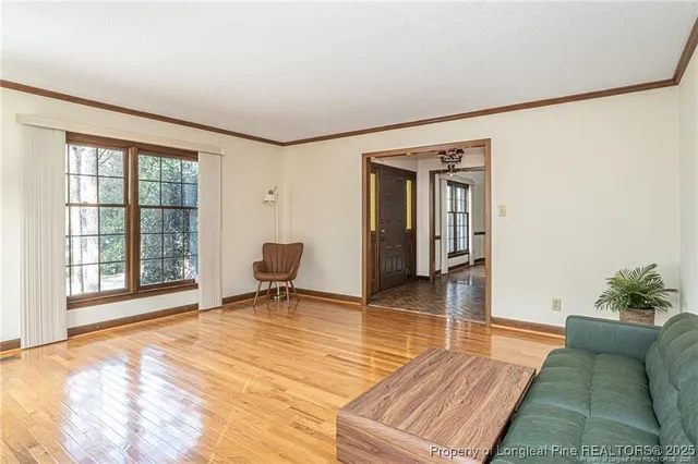 a view of a livingroom with wooden floor and furniture