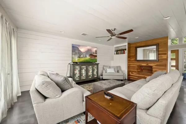 a living room with furniture a ceiling fan and a window