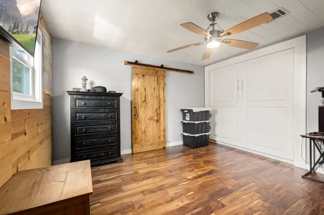 a room with furniture a large window and wooden floor