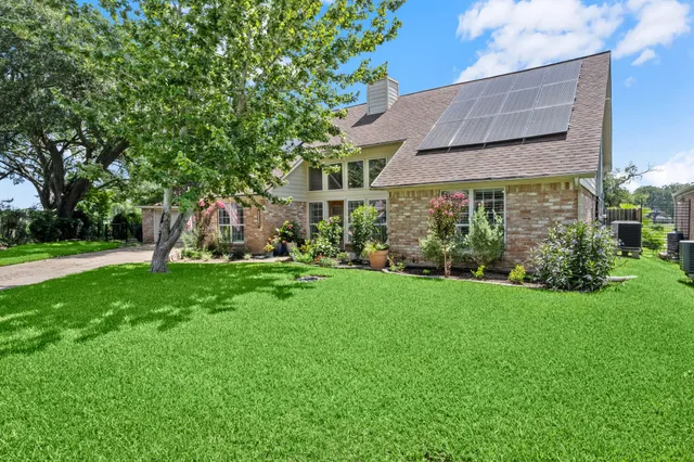 a view of a house with backyard and a tree