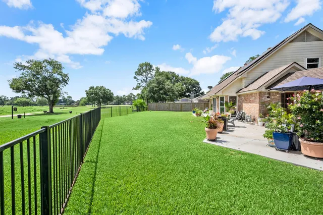 a view of a table and chairs under an umbrella in a big yard