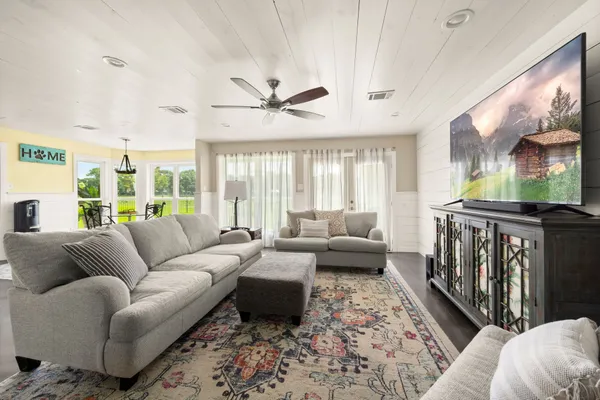 a living room with furniture wooden floor and a large window