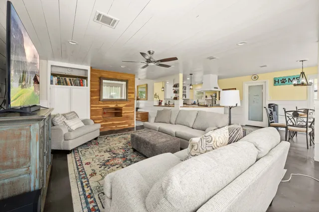 a living room with furniture a ceiling fan and a window