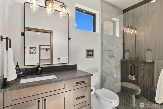 a bathroom with a toilet a sink and glass door