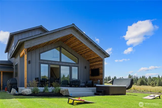 a view of a house with couches and a table and chairs under an umbrella