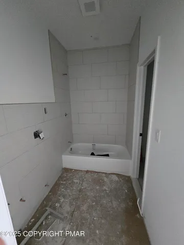 a bed sitting in a spacious bedroom and window