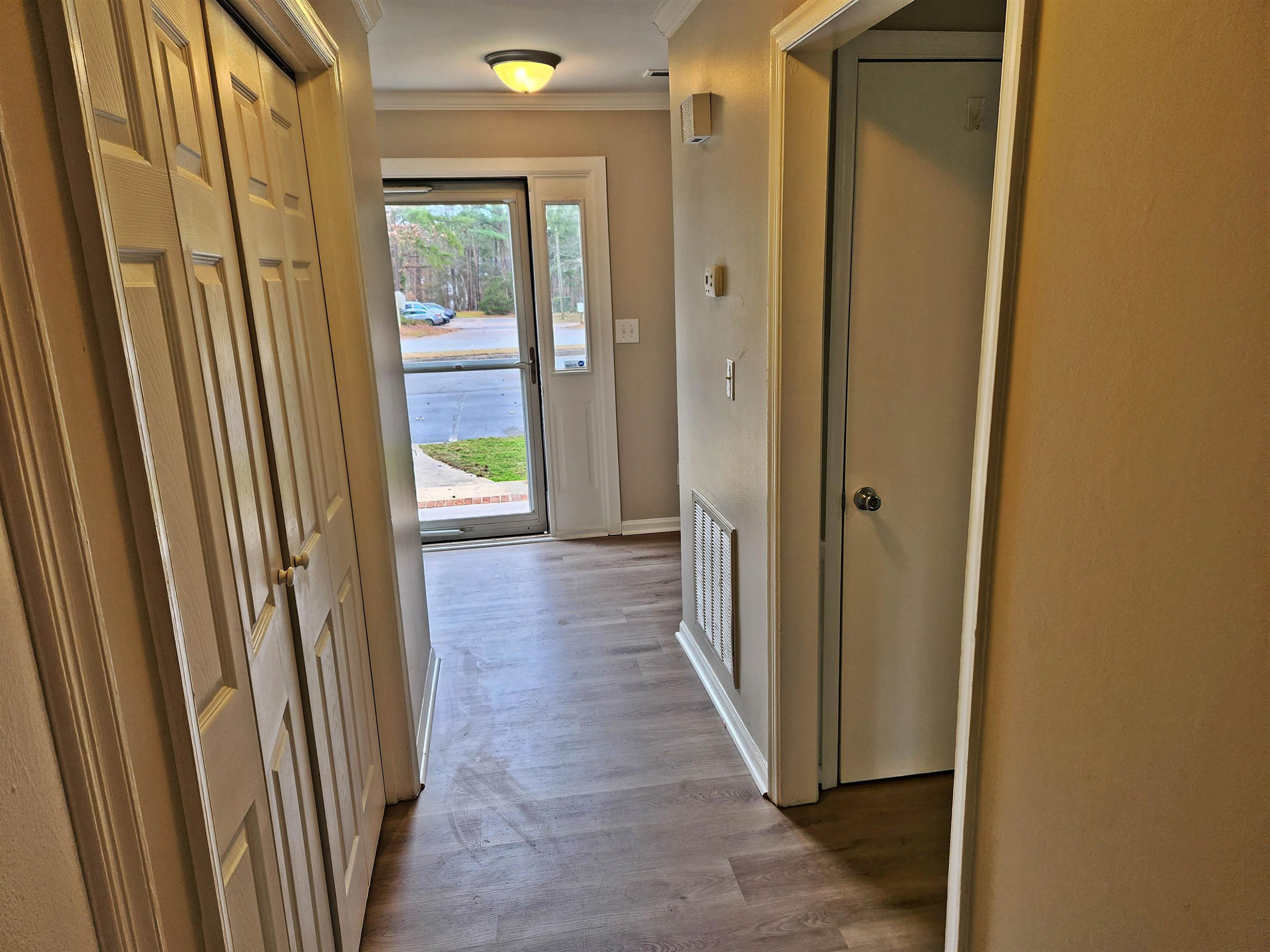 1227 Seaton Road, Unit 66 Durham, NC 27713 - Photo 6 of 29 a view of a hallway with wooden floor and glass door
