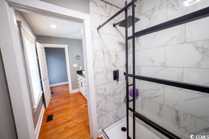 936 Oak Ridge Place Myrtle Beach, SC 29572 - Photo 17 of 36 Bathroom featuring a marble finish shower and light wood finished floors