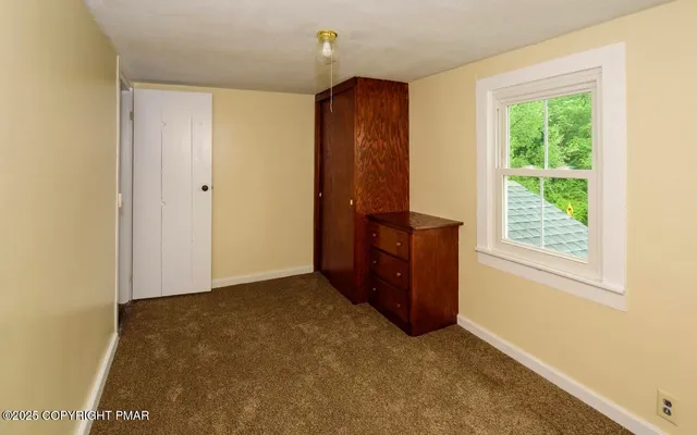 an empty room with windows and an entrance