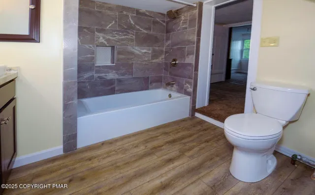 a bathroom with a granite countertop sink a mirror and a bathtub
