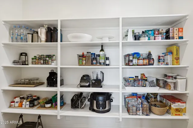 a spacious bedroom with a large bed and a chandelier fan