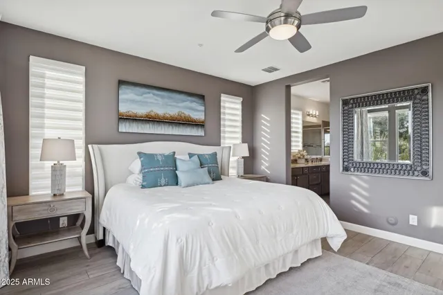 a spacious bathroom with a granite countertop double vanity sink a mirror and a bathtub