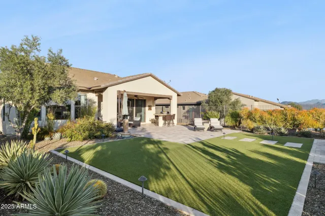 a view of a patio with couches chairs potted plants and a small yard