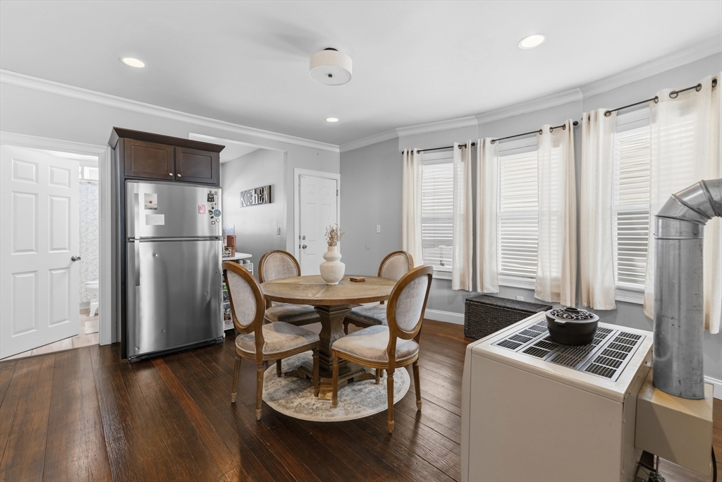 233 Belleville Road New Bedford, MA 02745 - Photo 12 of 40 a kitchen with stainless steel appliances granite countertop a stove a refrigerator a microwave a dining table and chairs with wooden floor