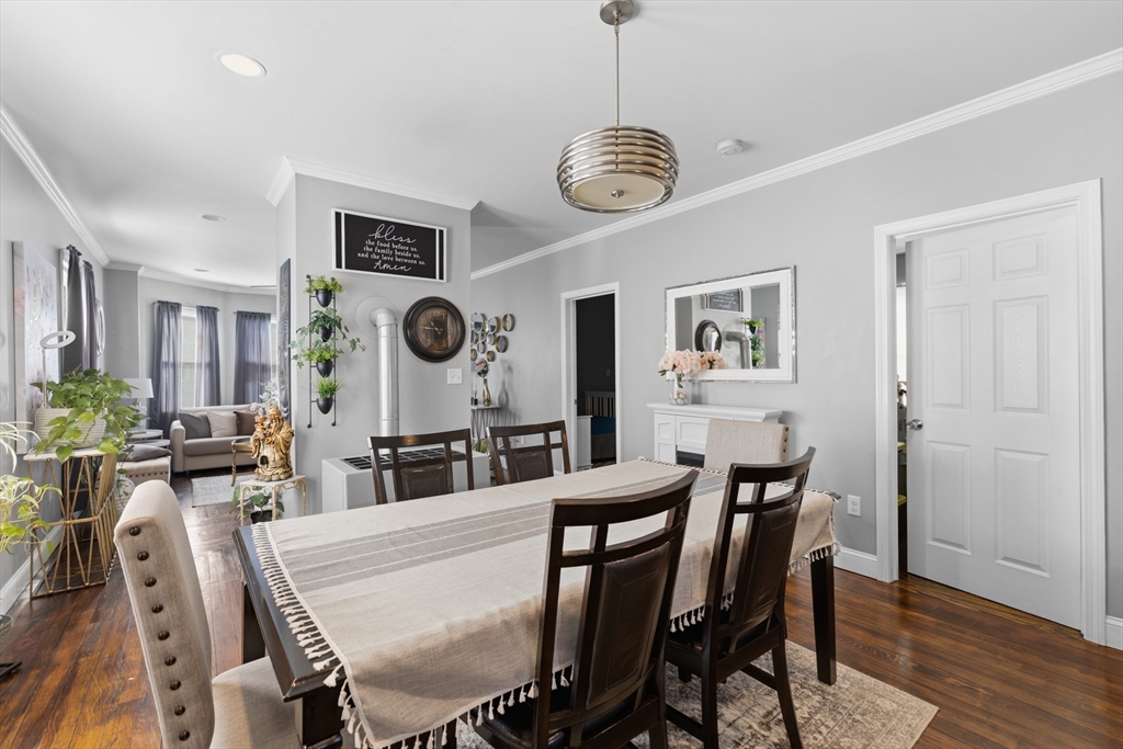 233 Belleville Road New Bedford, MA 02745 - Photo 21 of 40 a view of a dining room and livingroom with furniture wooden floor a rug a painting and a chandelier