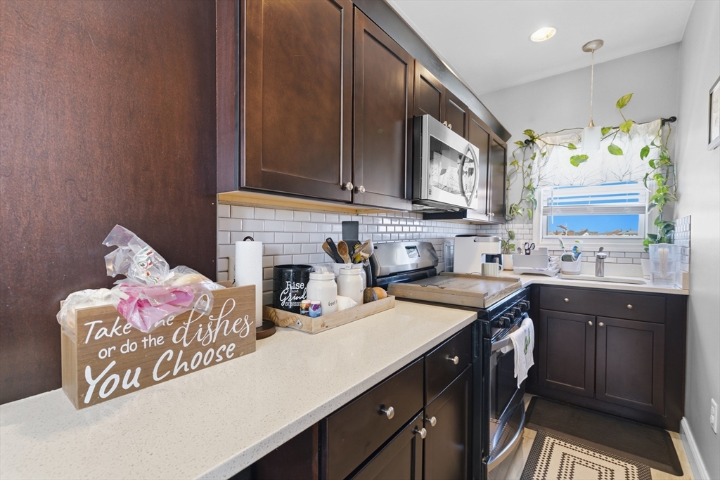 233 Belleville Road New Bedford, MA 02745 - Photo 27 of 40 a kitchen with a sink stove and cabinets