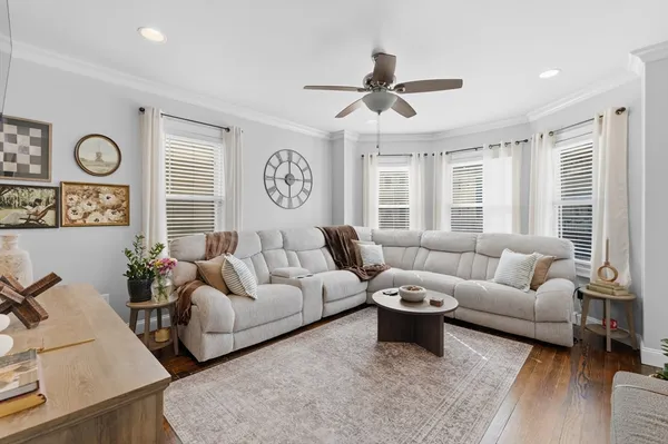 a living room with furniture a clock and a window