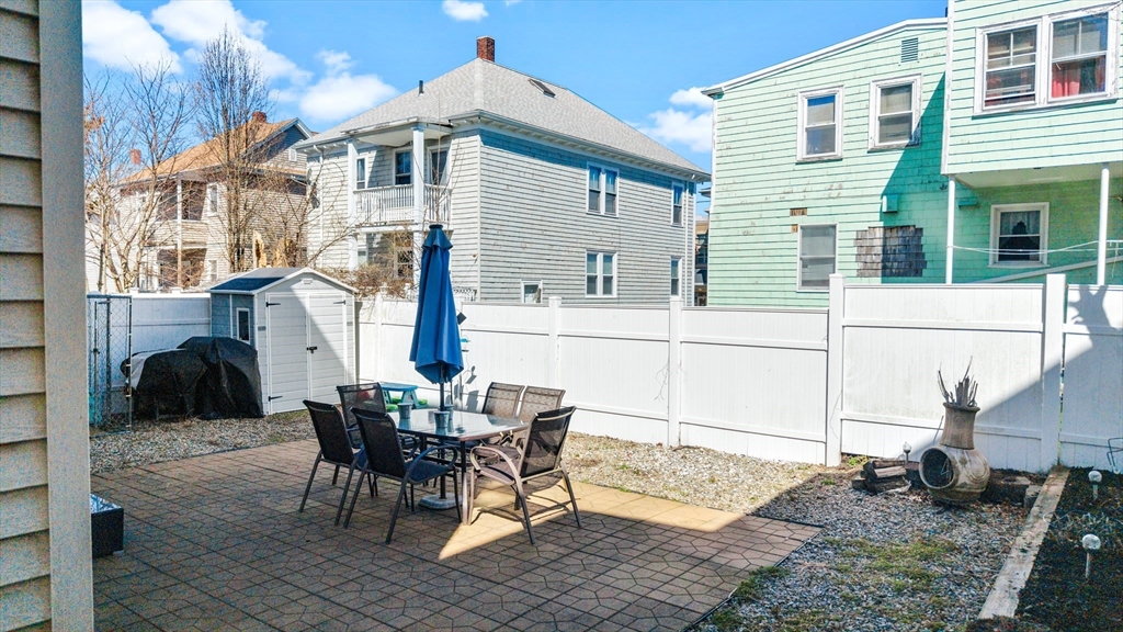 233 Belleville Road New Bedford, MA 02745 - Photo 35 of 40 a view of a patio with table and chairs and floor to ceiling window