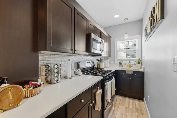 a kitchen with stainless steel appliances granite countertop a sink stove and cabinets