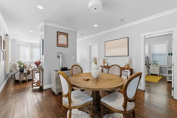 a view of a a dining room with furniture window and wooden floor