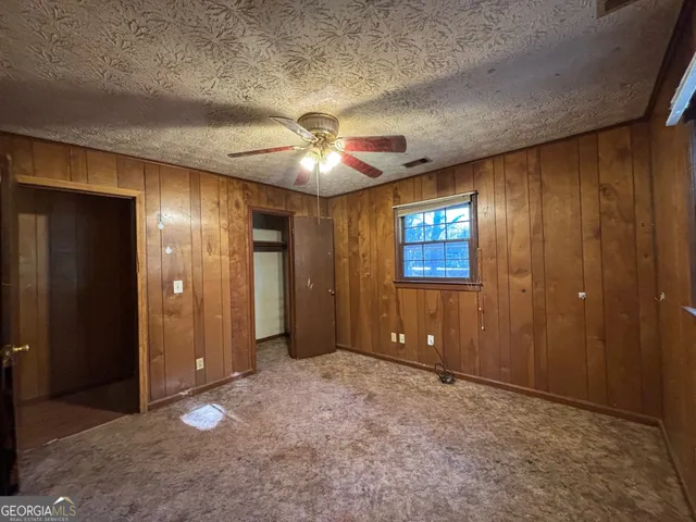 an empty room with closet and chandelier fan