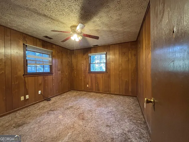 an empty room with windows and closet