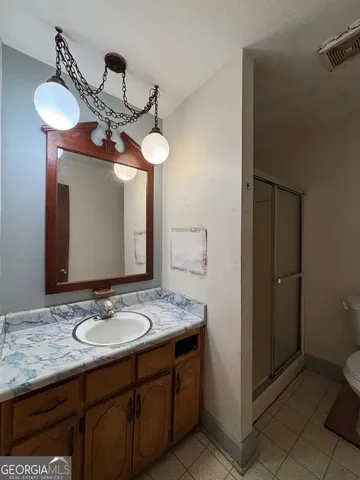 a bathroom with a granite countertop sink a toilet and mirror