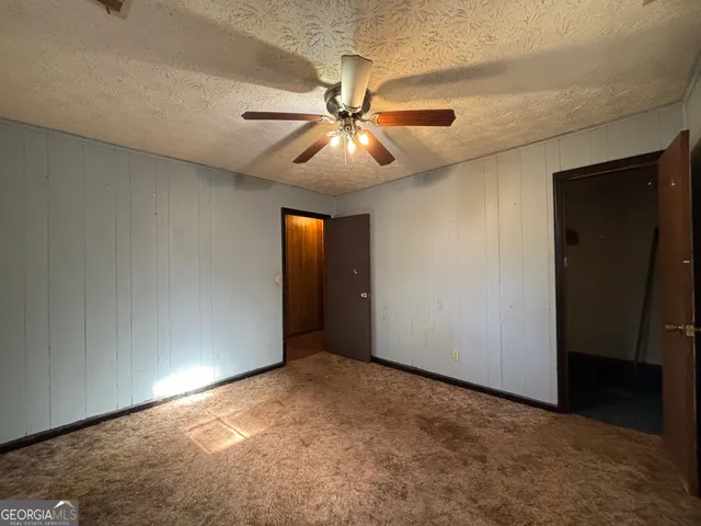 en empty room with windows and fan