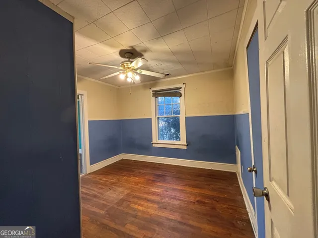 an empty room with windows and fan