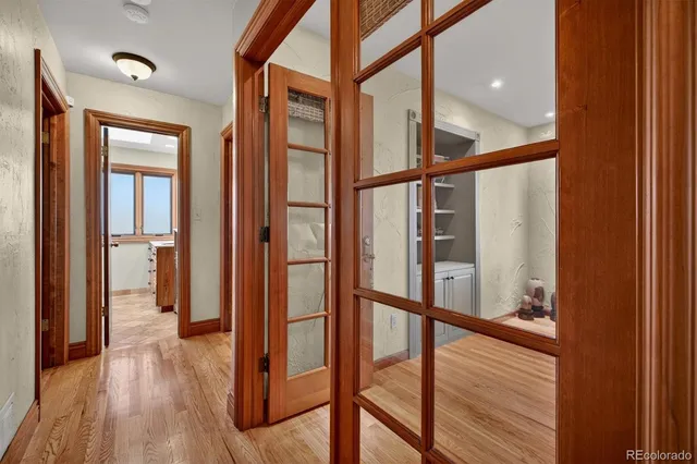 a view of a hallway with wooden floor and staircase