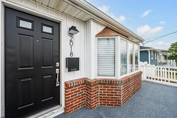 a porch with a bench next to a yard