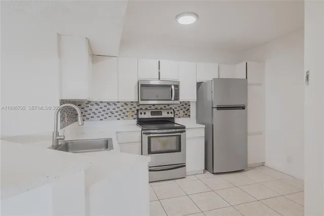 a kitchen with cabinets and stainless steel appliances