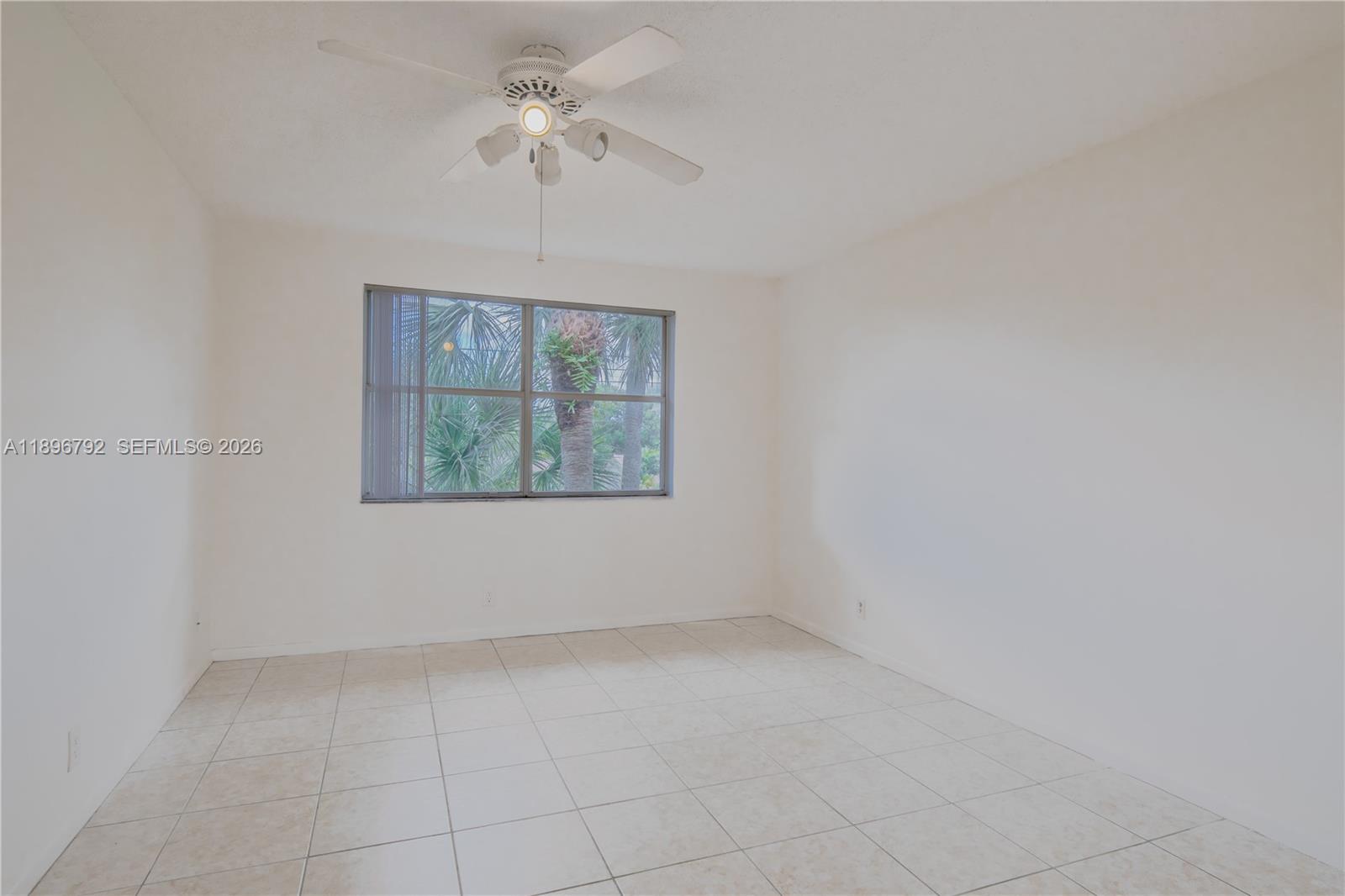 9033 Wiles Road, Unit 303 Coral Springs, FL 33067 - Photo 6 of 17 an empty room with windows and fan