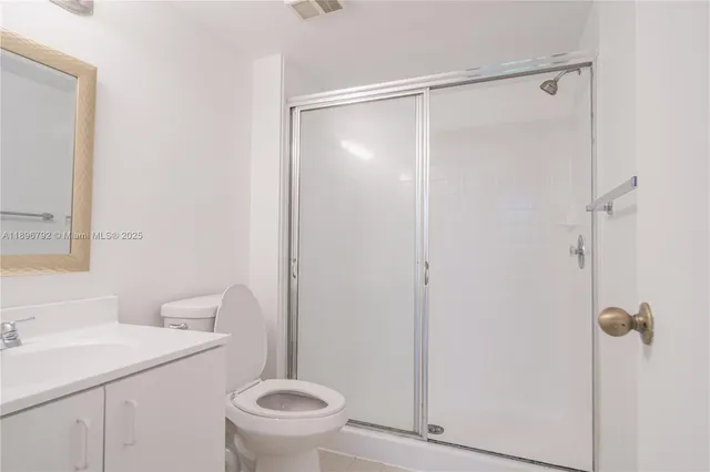 a bathroom with a shower a toilet and a sink