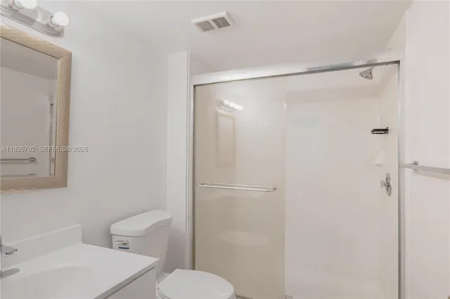 a bathroom with a shower a toilet and sink