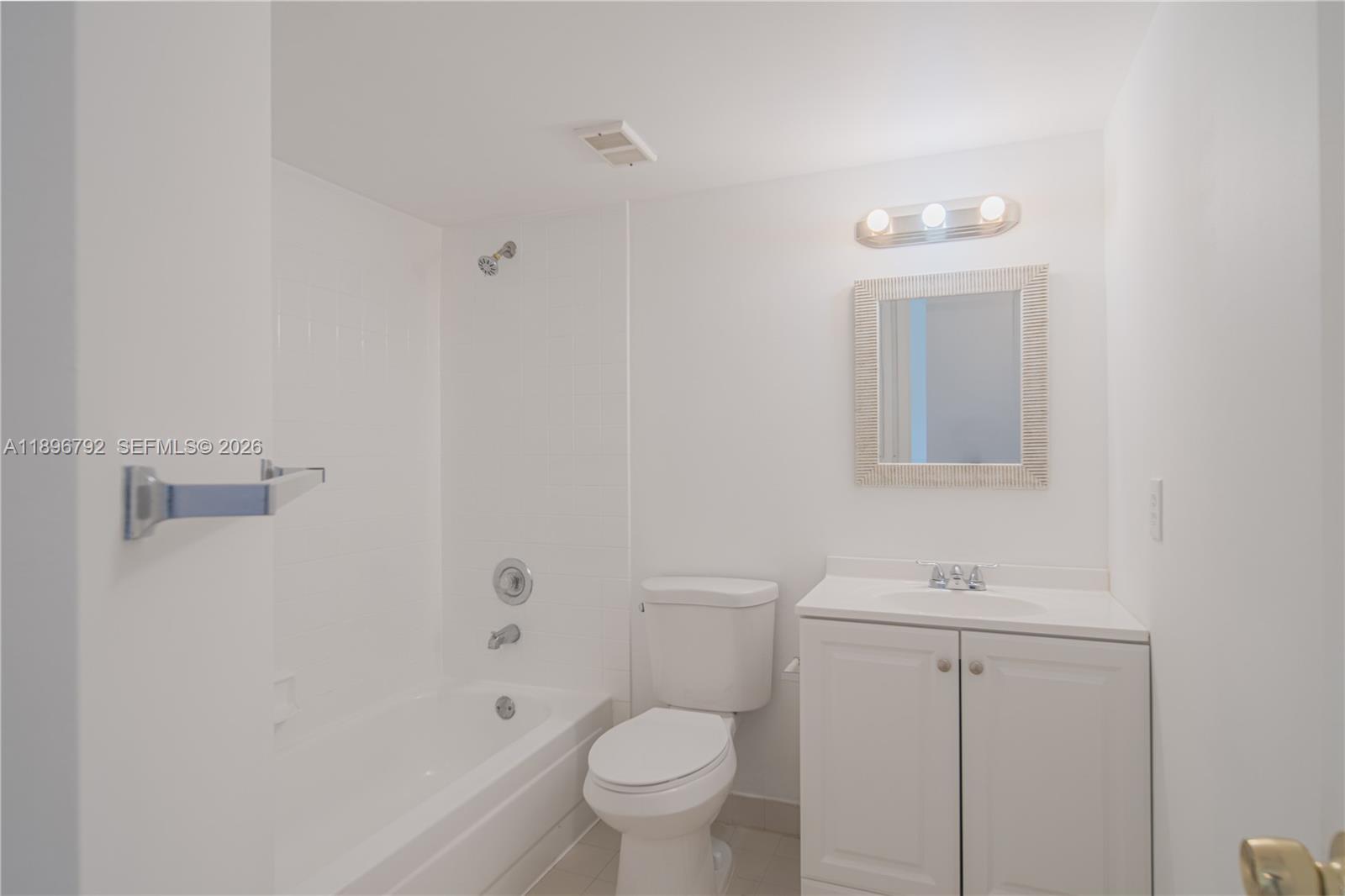 9033 Wiles Road, Unit 303 Coral Springs, FL 33067 - Photo 10 of 17 a bathroom with a toilet a sink a shower and mirror