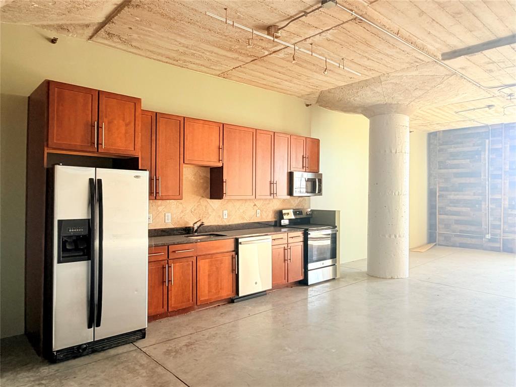 1122 Jackson Street, Unit 802 Dallas, TX 75202 - Photo 3 of 8 a kitchen with stainless steel appliances granite countertop a refrigerator and a stove top oven