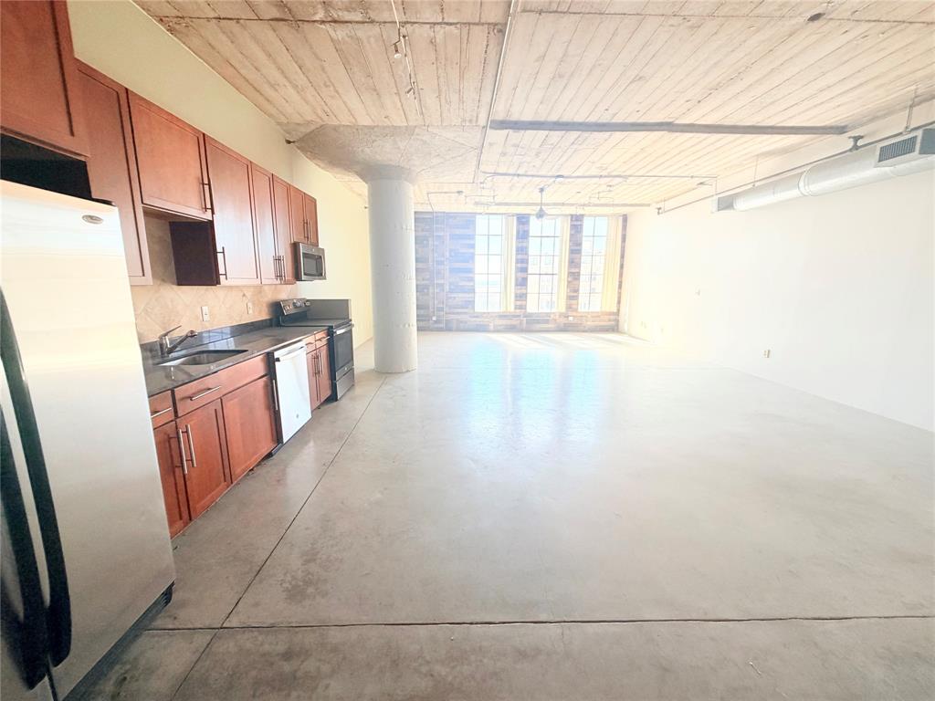1122 Jackson Street, Unit 802 Dallas, TX 75202 - Photo 4 of 8 a kitchen with stainless steel appliances a refrigerator and a stove