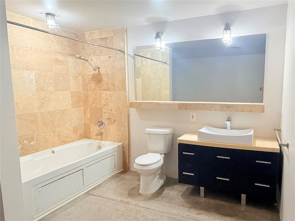 1122 Jackson Street, Unit 802 Dallas, TX 75202 - Photo 6 of 8 a bathroom with a sink a toilet and shower