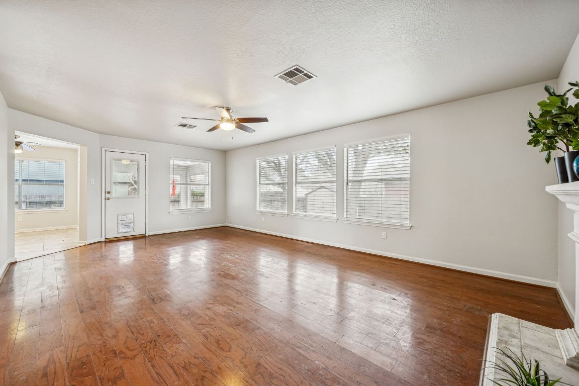 8611 Devine Lane Austin, TX 78748 - Photo 12 of 33 a view of an empty room with a window and wooden floor