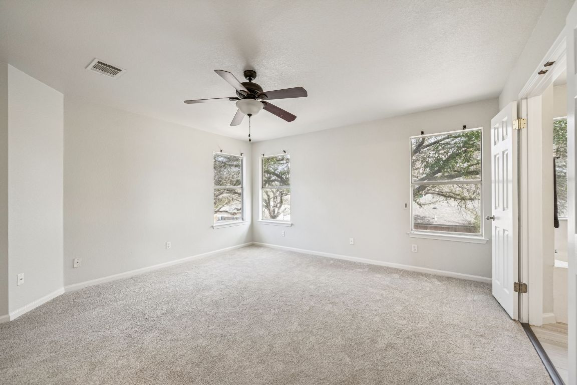 8611 Devine Lane Austin, TX 78748 - Photo 23 of 33 en empty room with windows and ceiling fan
