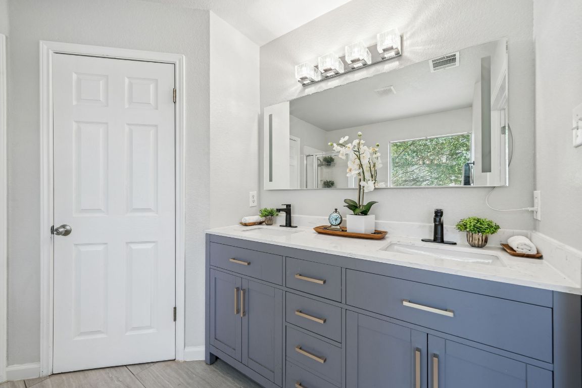 8611 Devine Lane Austin, TX 78748 - Photo 25 of 33 a en suite bathroom with a granite countertop sink and a mirror