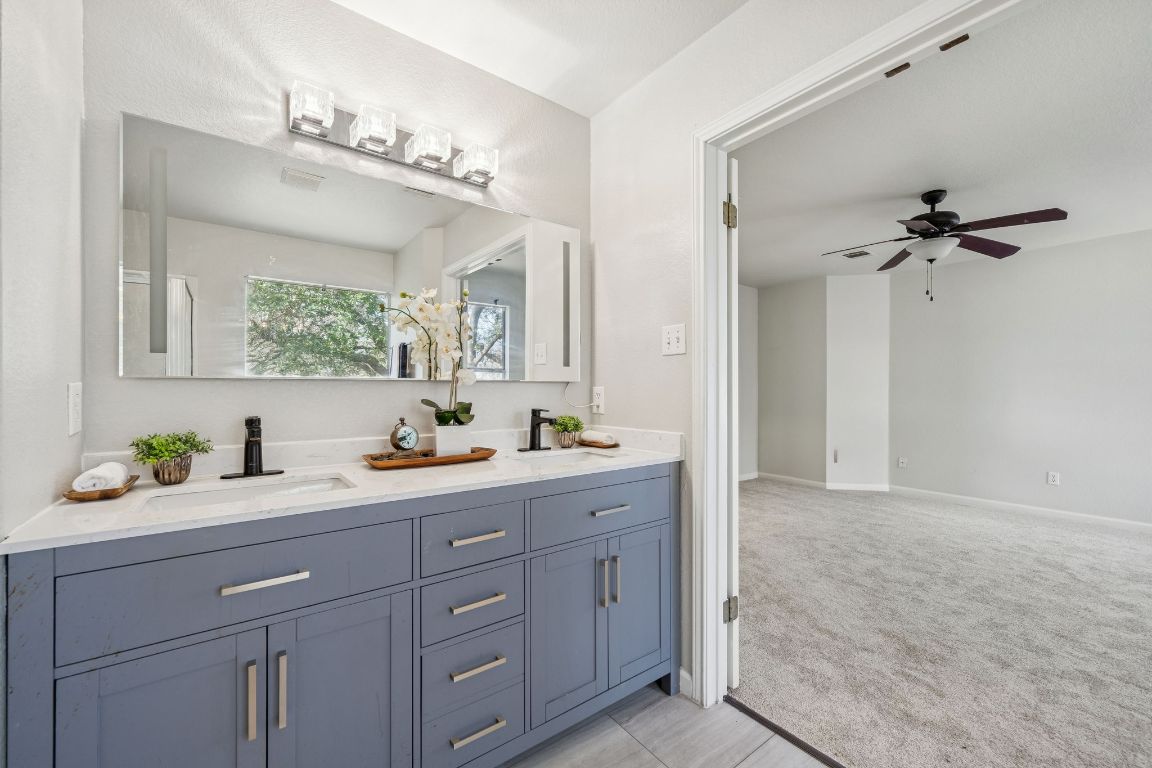 8611 Devine Lane Austin, TX 78748 - Photo 26 of 33 a bathroom with a granite countertop sink a mirror and a vanity