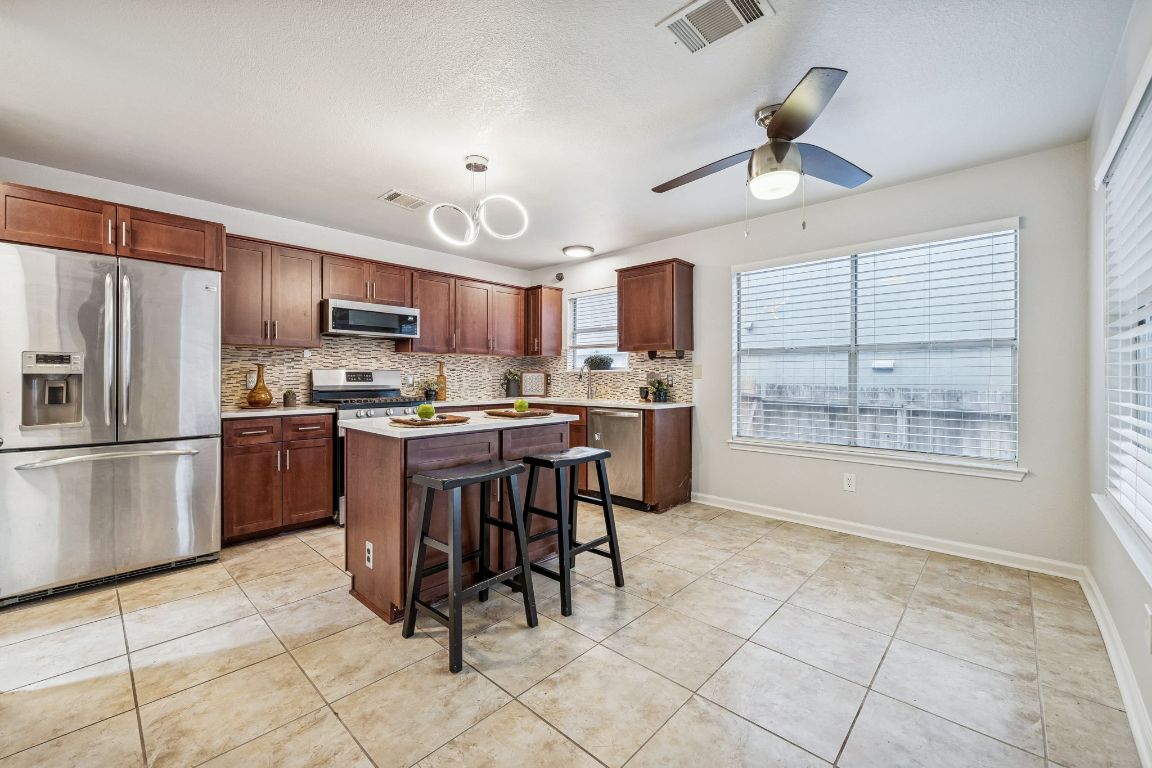 8611 Devine Lane Austin, TX 78748 - Photo 9 of 33 a kitchen with stainless steel appliances granite countertop a refrigerator a sink a stove and a refrigerator