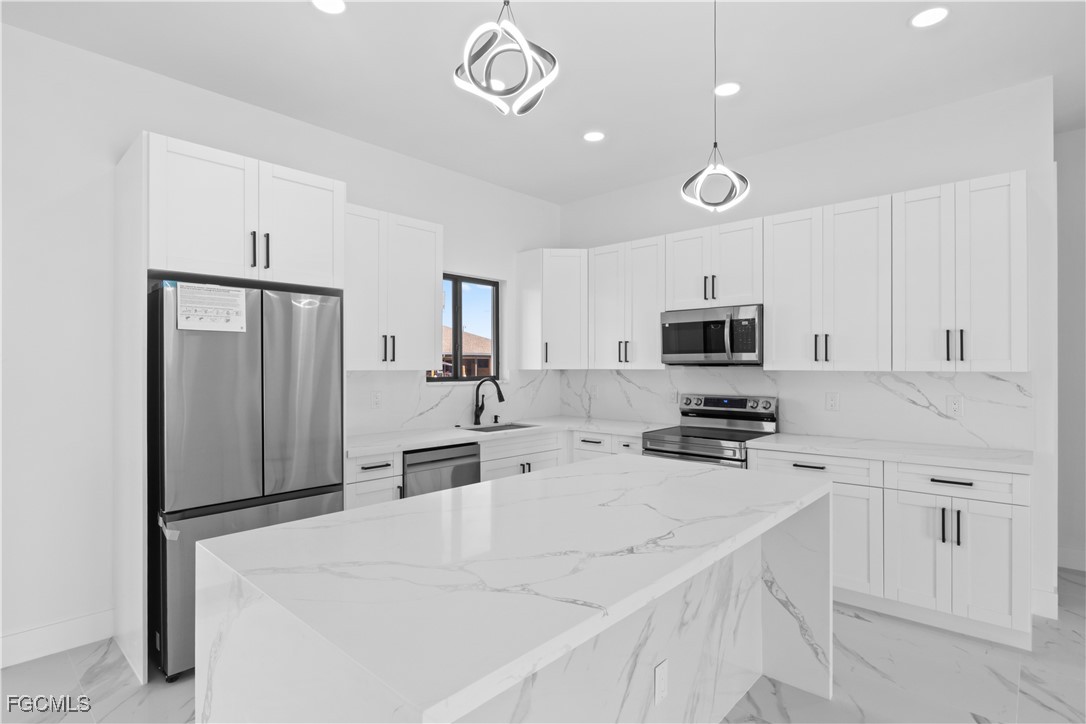 4006 5th Street Southwest Lehigh Acres, FL 33976 - Photo 19 of 32 a kitchen with stainless steel appliances a refrigerator sink and microwave