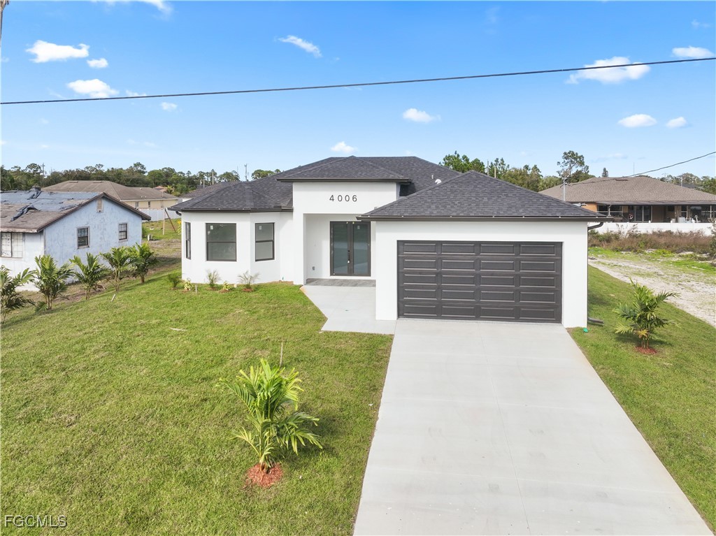4006 5th Street Southwest Lehigh Acres, FL 33976 - Photo 3 of 32 a front view of a house with a garden