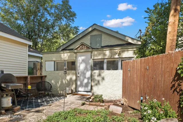 a front view of house with yard and trees in the background