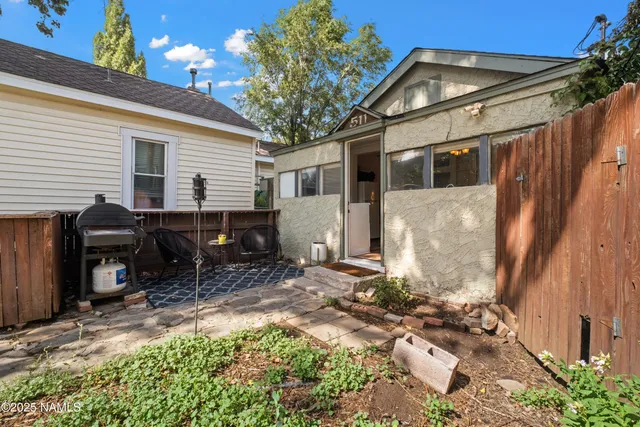 a backyard of a house with table and chairs